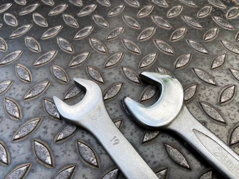Set of 2 wrenches placed on a dark steel background - Top View Stock Photos