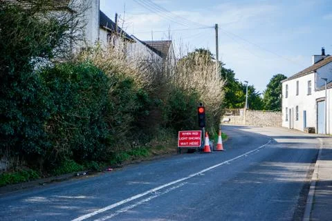 A set of 3-way lights control the flow of traffic at a village junction Stock Photos