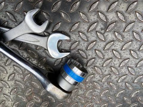Set of 3 wrenches placed on a dark steel background - Top View Stock Photos
