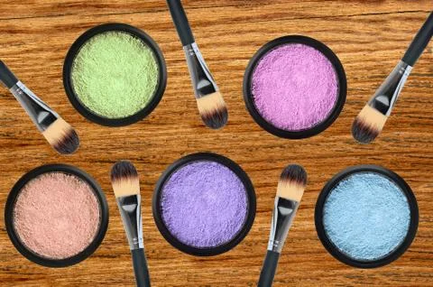 Set of 5 eyeshadows and brushes over wooden texture close-up Stock Photos