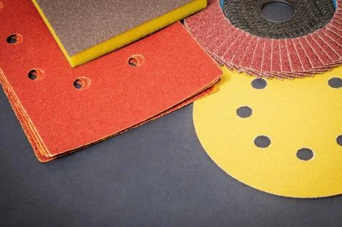 Set of abrasive tools and brown sandpaper on black workshop table wizard is u Stock Photos