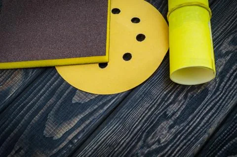 Set of abrasive tools and sandpaper on dark vintage wood background. Stock Photos