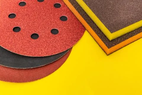 Set of abrasive tools and sandpaper on yellow background Stock Photos