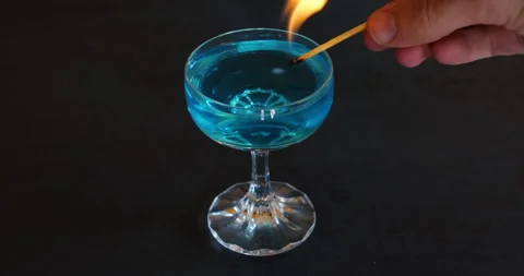 Set the alcohol on fire. fire with a match. cocktail on fire. blue alcohol Video stock 252451619
