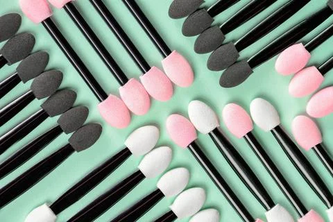 Set of applicators for applying shadows on green background. Stock Photos
