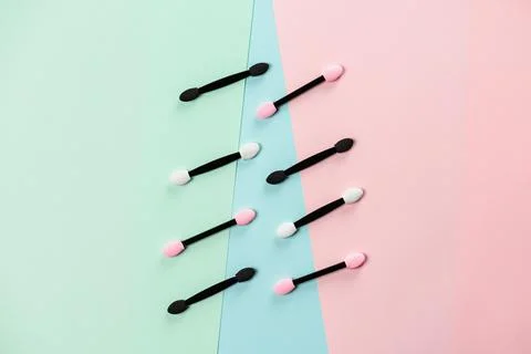 Set of applicators for applying shadows on multicolored background. Stock Photos