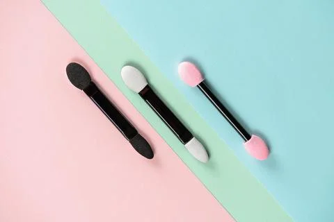 Set of applicators for applying shadows on multicolored background. Stock Photos