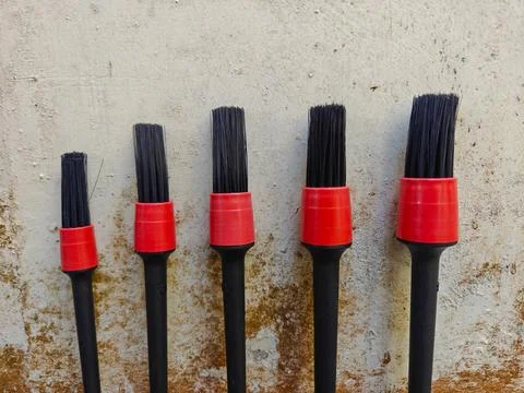 Set of Auto Detailing Brushes in Various Sizes Against Textured Wall Stock-Fotos