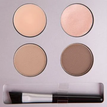 Set of beige eyeshadows and applicator brush Stock Photos