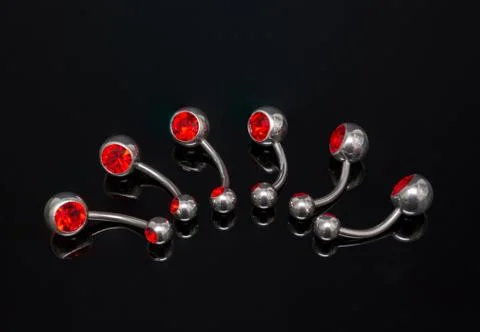 Set of belly piercing on black background. Body jewelry. Stock Photos