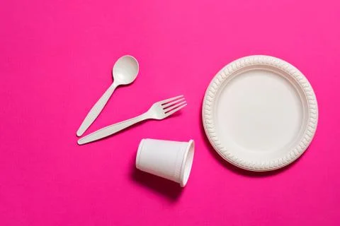 Set of biodegradable disposable tableware on a pink background. Stock Photos