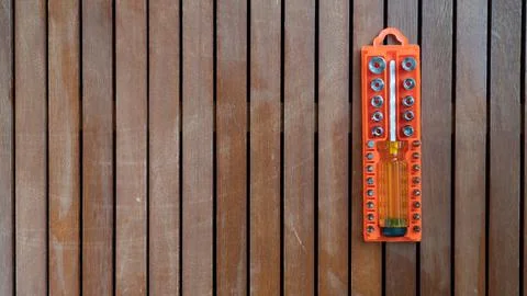 Set of bits and screwdrivers in orange case on wooden background Stock-Fotos