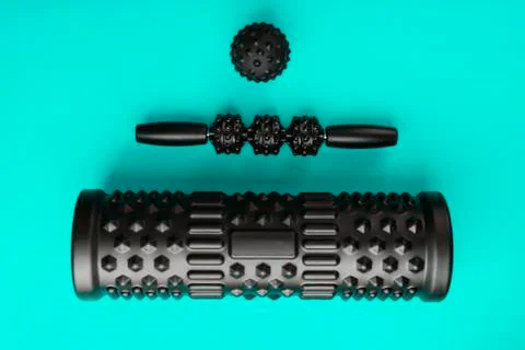 A set of black bumpy foam massage rollers, body rollers, rubber balls on a bl Stock Photos