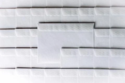Set of blank white envelopes lying in a row on the desk in the office, one en Stock Photos