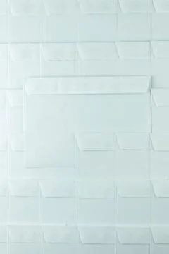 Set of blank white envelopes lying in a row on the desk in the office, one en Stock Photos