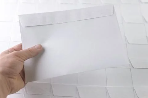 Set of blank white envelopes lying in a row on a desk in the office, one enve Stock Photos
