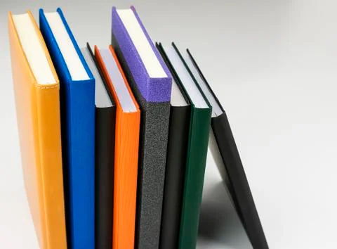 Set of books arranged vertically of different colors and sizes on white Stock Photos