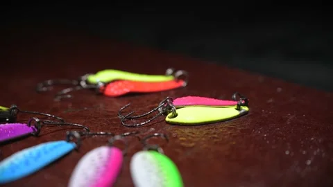 Set of bright, colorful trout spinners slowly rotating on fishing line against Stock Footage 166517631