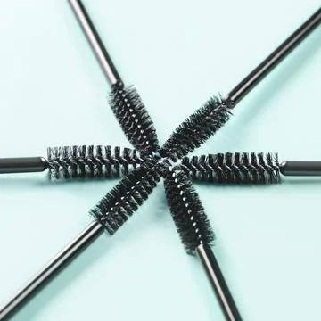 Set of brushes for eyelashes and eyebrows on blue background. Toned. Stock Photos
