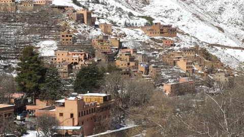 Set of buildings by the river with white mountain in Imlil Town, Morocco Vídeo Stock 328995832