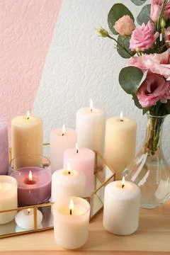 Set of burning candles on table against color background Foto stock