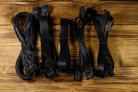 Set of cables for computer PSU on a wooden desk Stock Photos