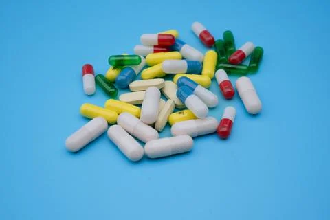 Set of capsules of different shaped  and  colors on a blue background. Heal.. Stock Photos