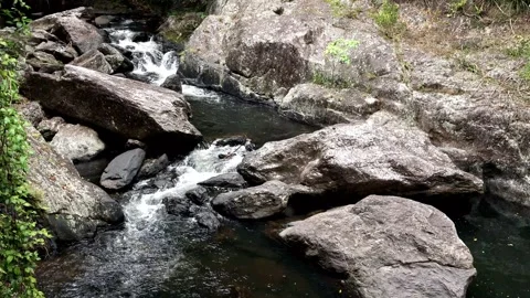 A set of cascades flowing through large rocks in a river bed Stock Footage 260020998