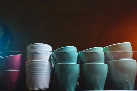 Set of ceramic colored cups or mugs heating on professional coffee machine Stock Photos