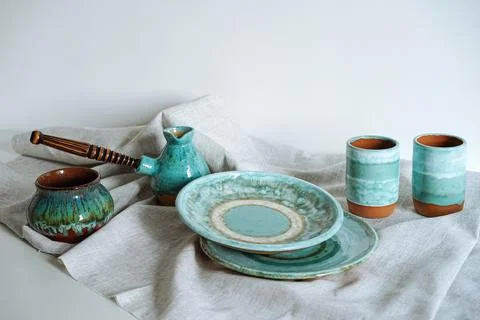 Set of ceramic tableware on a gray linen cloth Stock Photos