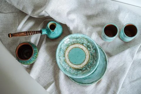 Set of ceramic tableware on a gray linen cloth Stock Photos
