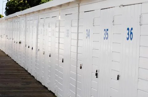 Set of changing cabins on the beach, all white with numbered doors Fotos Stock