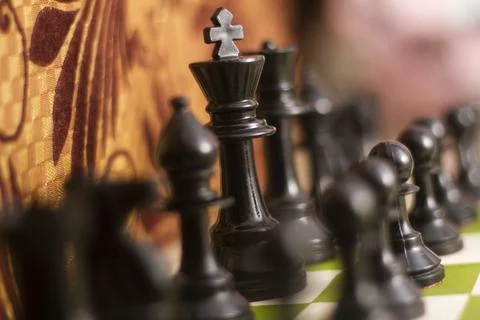 Set chess on a chessboard background focus on king Stock Photos