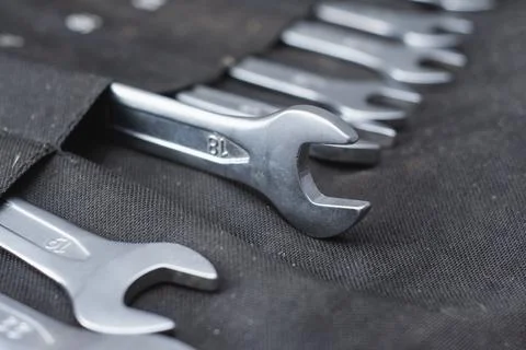 Set of chrome vanadium open end wrenches in a black textile tool roll pouch. Stock Photos