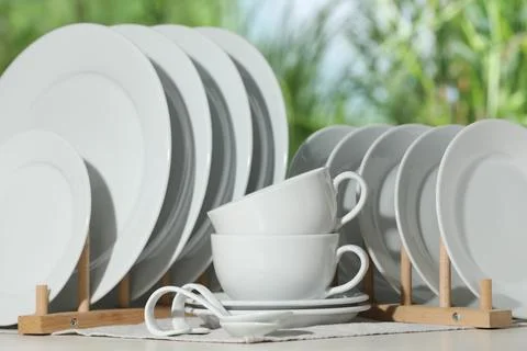 Set of clean dishware on white table against blurred background Foto stock