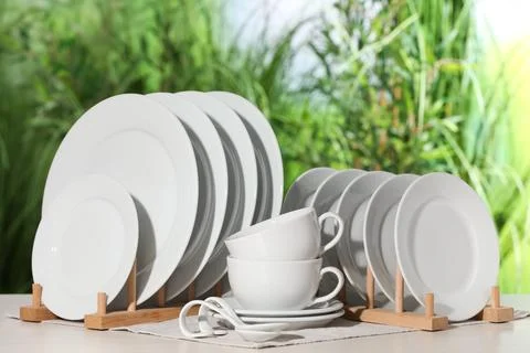 Set of clean dishware on white table against blurred background Foto stock