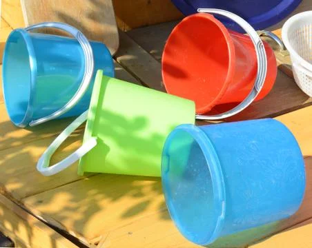 Set of clean multi-colored plastic buckets, outdoor, on a Sunny summer day in Stock Photos