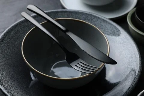 Set of clean tableware on black table, closeup Stock Photos