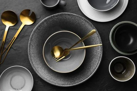 Set of clean tableware on black table, flat lay Stock Photos