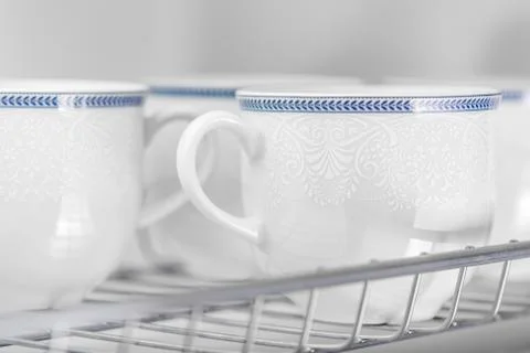 Set of clean white cups located on the shelf Stock Photos