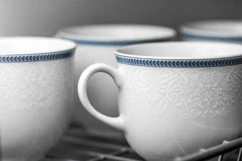 Set of clean white cups located on the shelf Stock Photos
