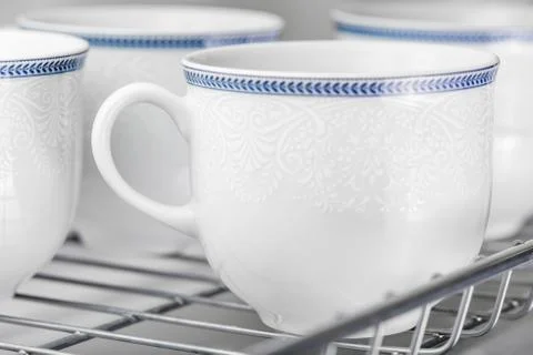 Set of clean white cups located on the shelf Stock Photos