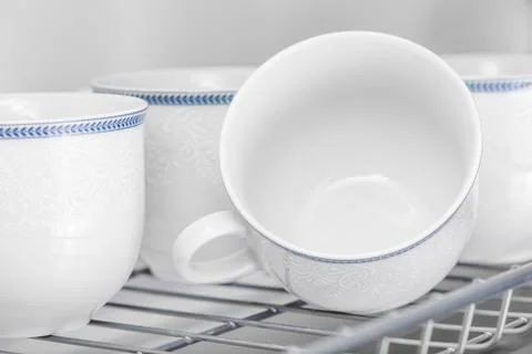 Set of clean white cups located on the shelf Stock Photos