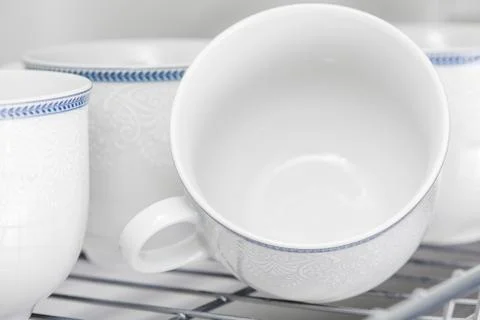 Set of clean white cups located on the shelf Stock Photos