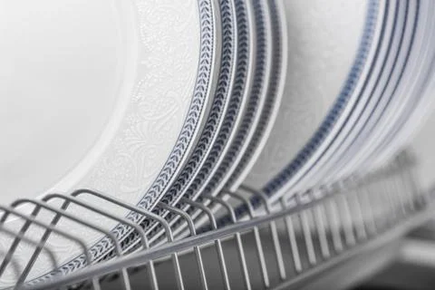 Set of clean white plates located in cupboard Stock Photos