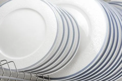 Set of clean white plates located in cupboard Stock Photos