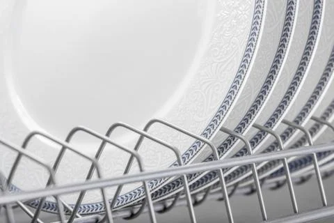 Set of clean white plates located in cupboard Stock Photos