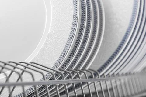 Set of clean white plates located in cupboard Stock Photos