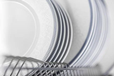 Set of clean white plates located in cupboard Stock Photos