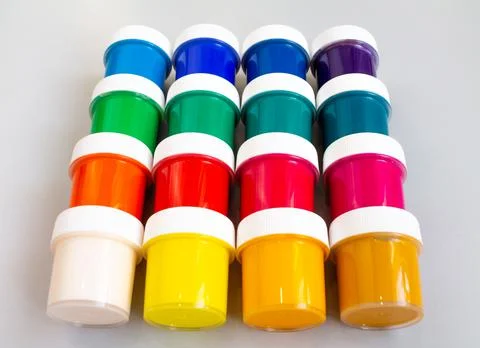 A set of closed jars with gouache of different colors are laid out in rows on a Stock Photos